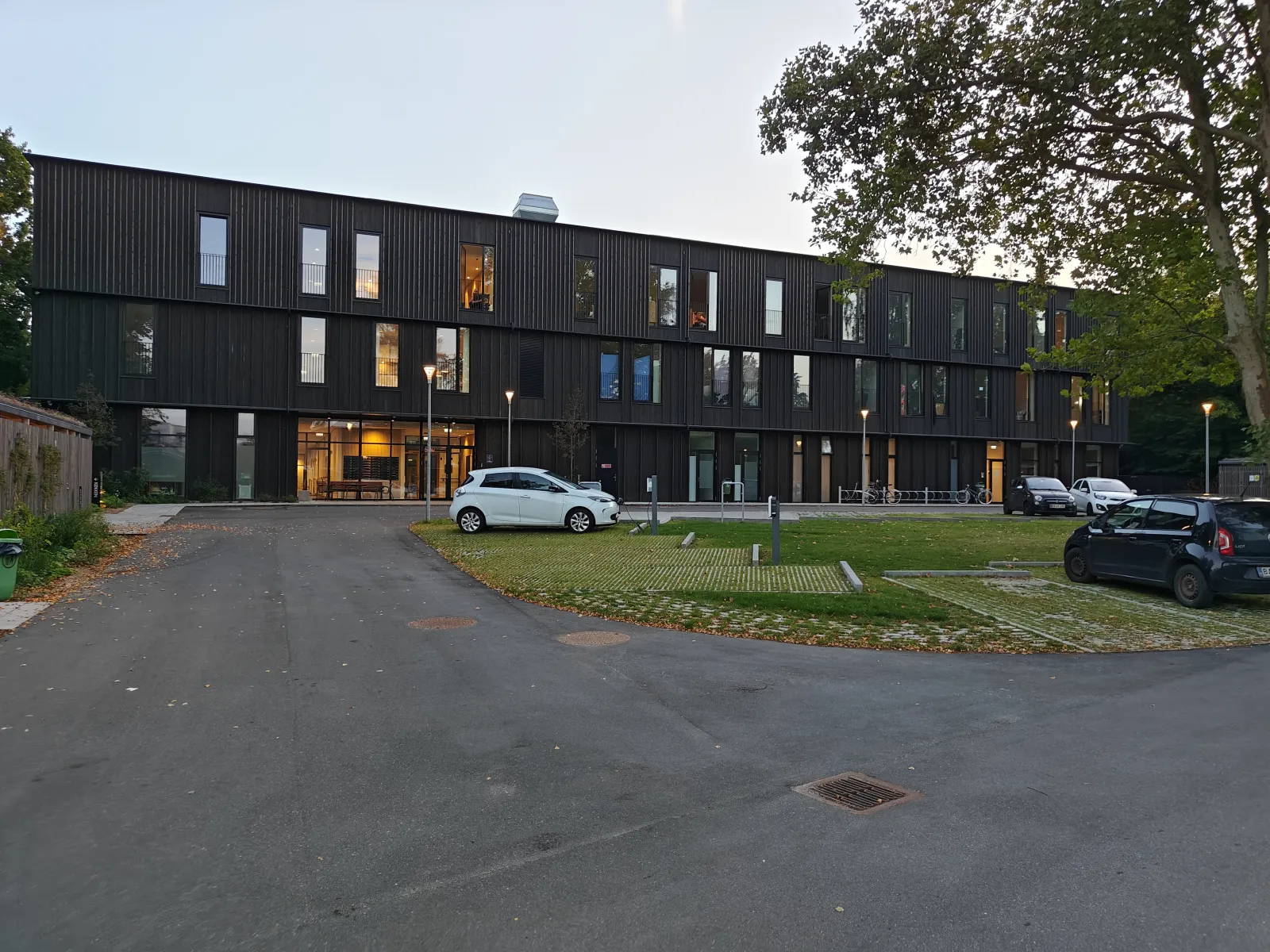 Moderne etagebyggeri med biler langs adgangsvejen