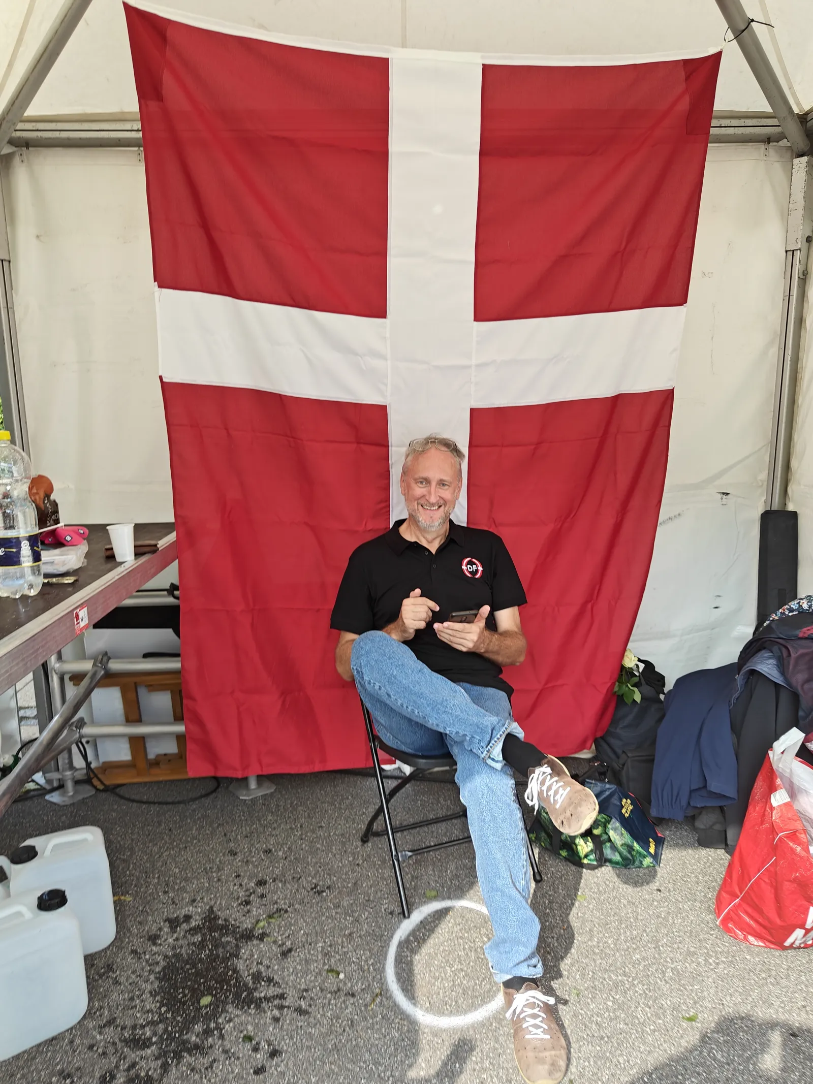 Mand sidder foran et stort dansk flag